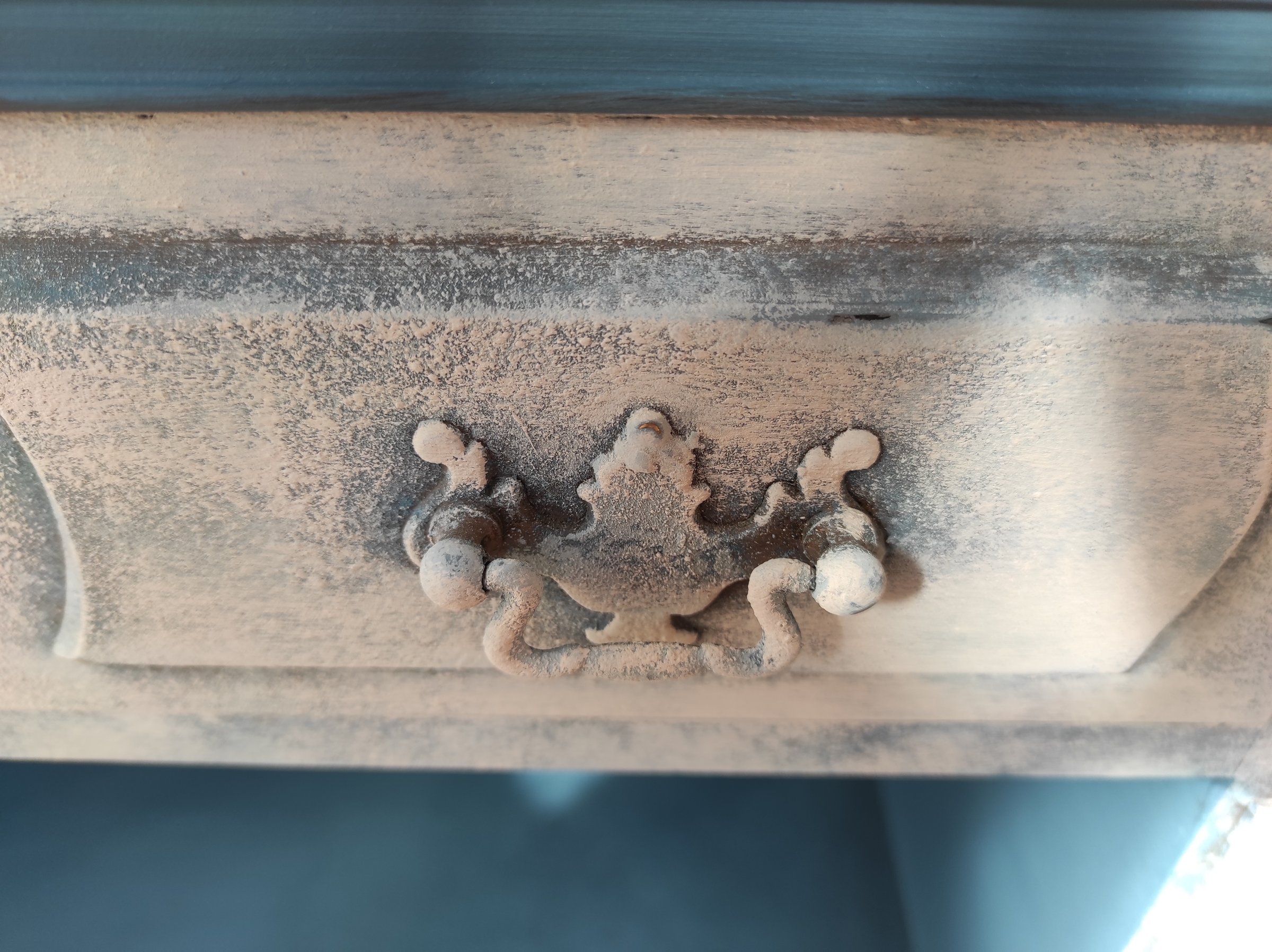 Maniglia decorata del cassetto su fondo chiaro sfumato di blu