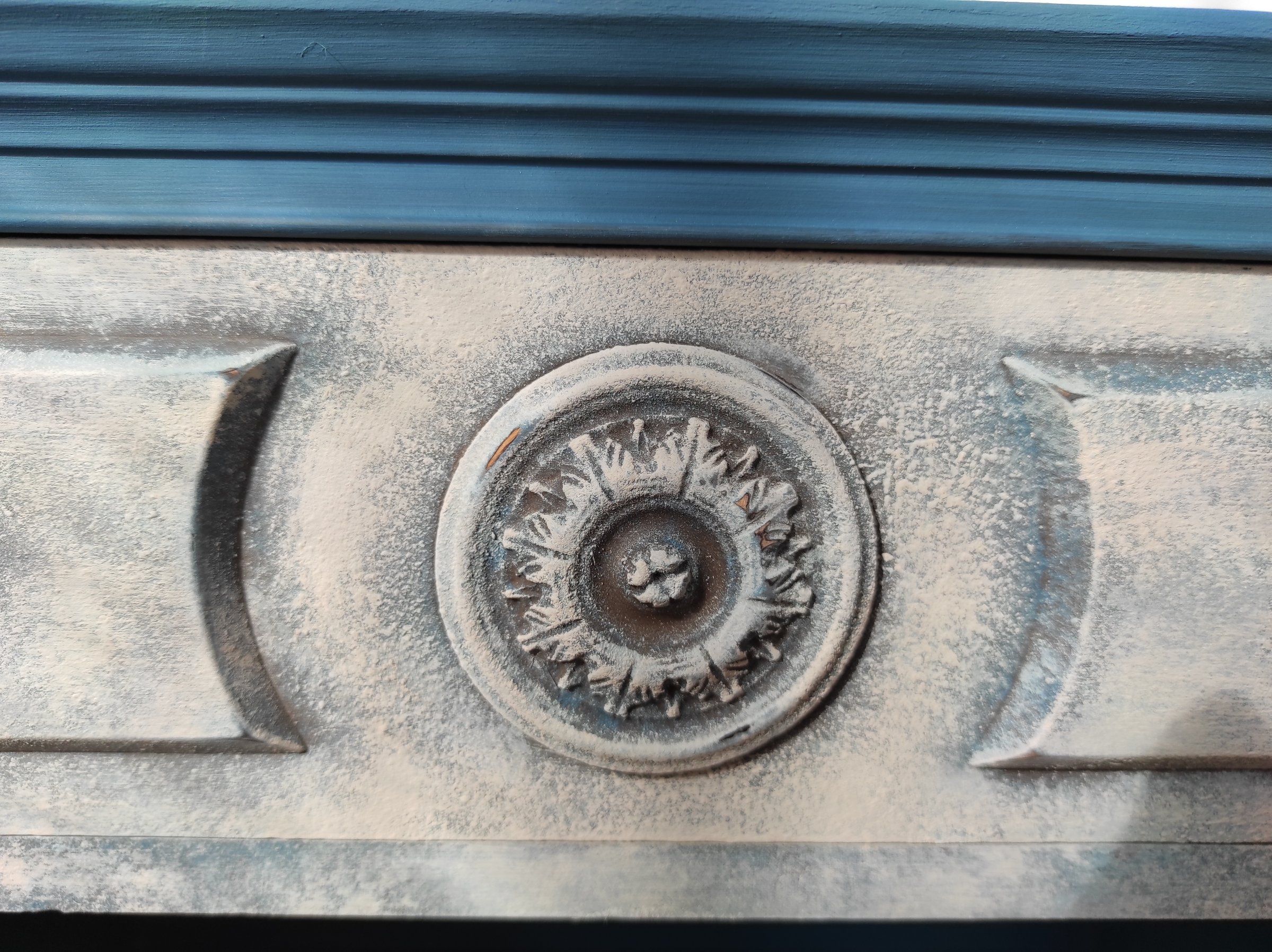 Dettaglio del rosone sul cassetto con finitura materica bianco-grigio