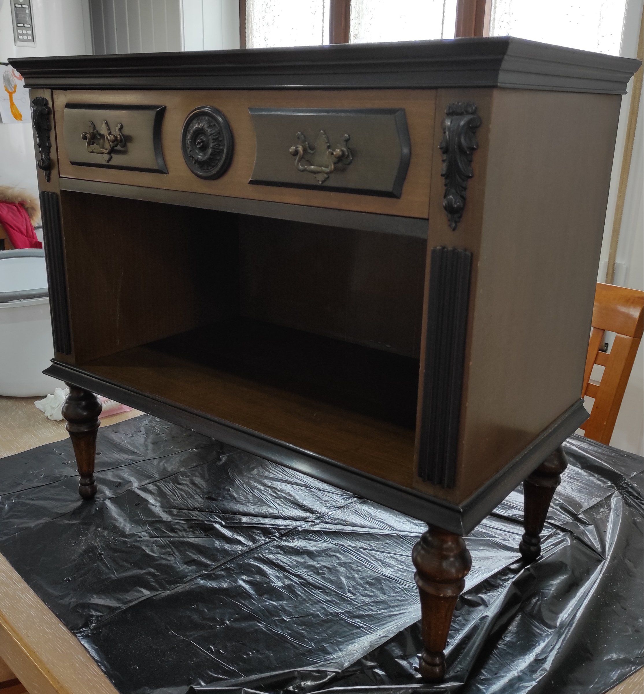 Comodino prima del restyling in legno scuro con cassetto, rosone centrale e gambe tornite