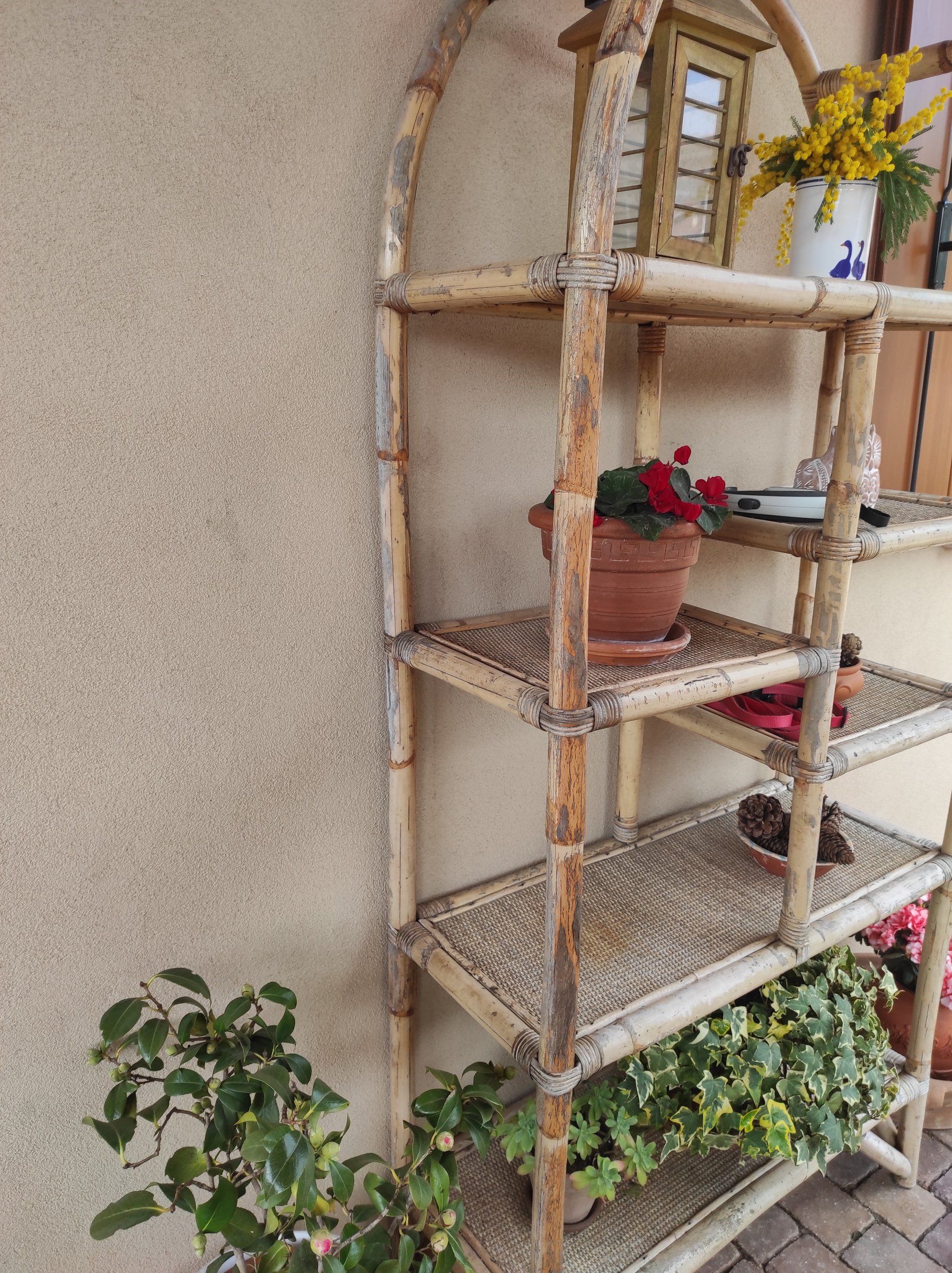 Scaffale in bamboo prima del restyling, con la vernice crepata e scrostata, sotto il portico