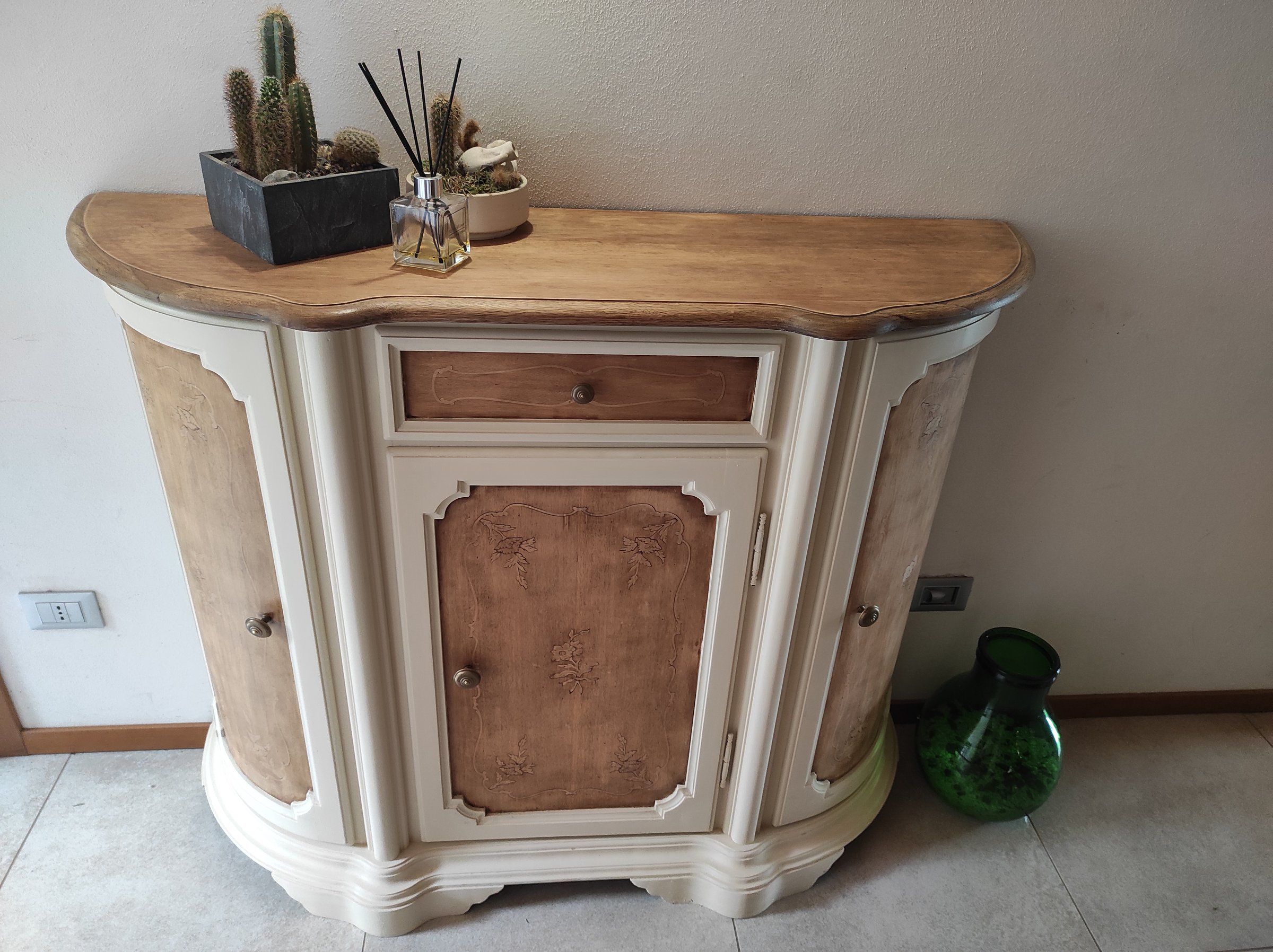 Mobile da ingresso sagomato dopo il restyling: struttura color crema, pannelli delle ante e piano in tono legno
