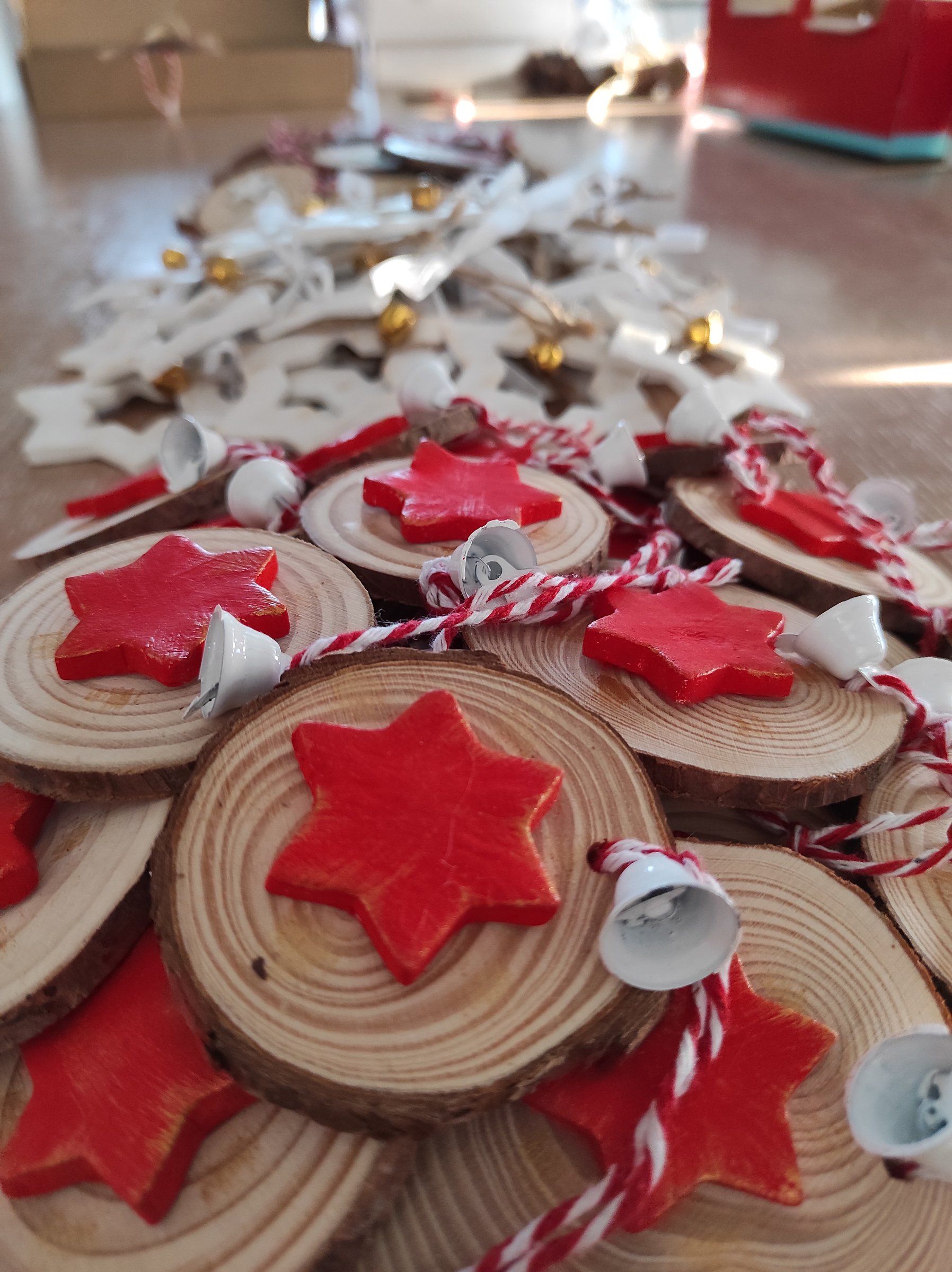 Fette di legno decorate con gnomi, stelle e bacche, con nastri bianchi e rossi