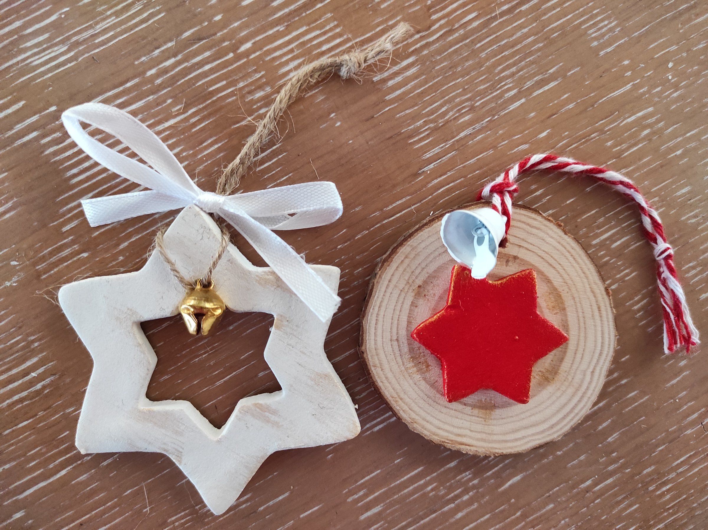 Stella bianca traforata con nastro e fetta di legno con stella rossa