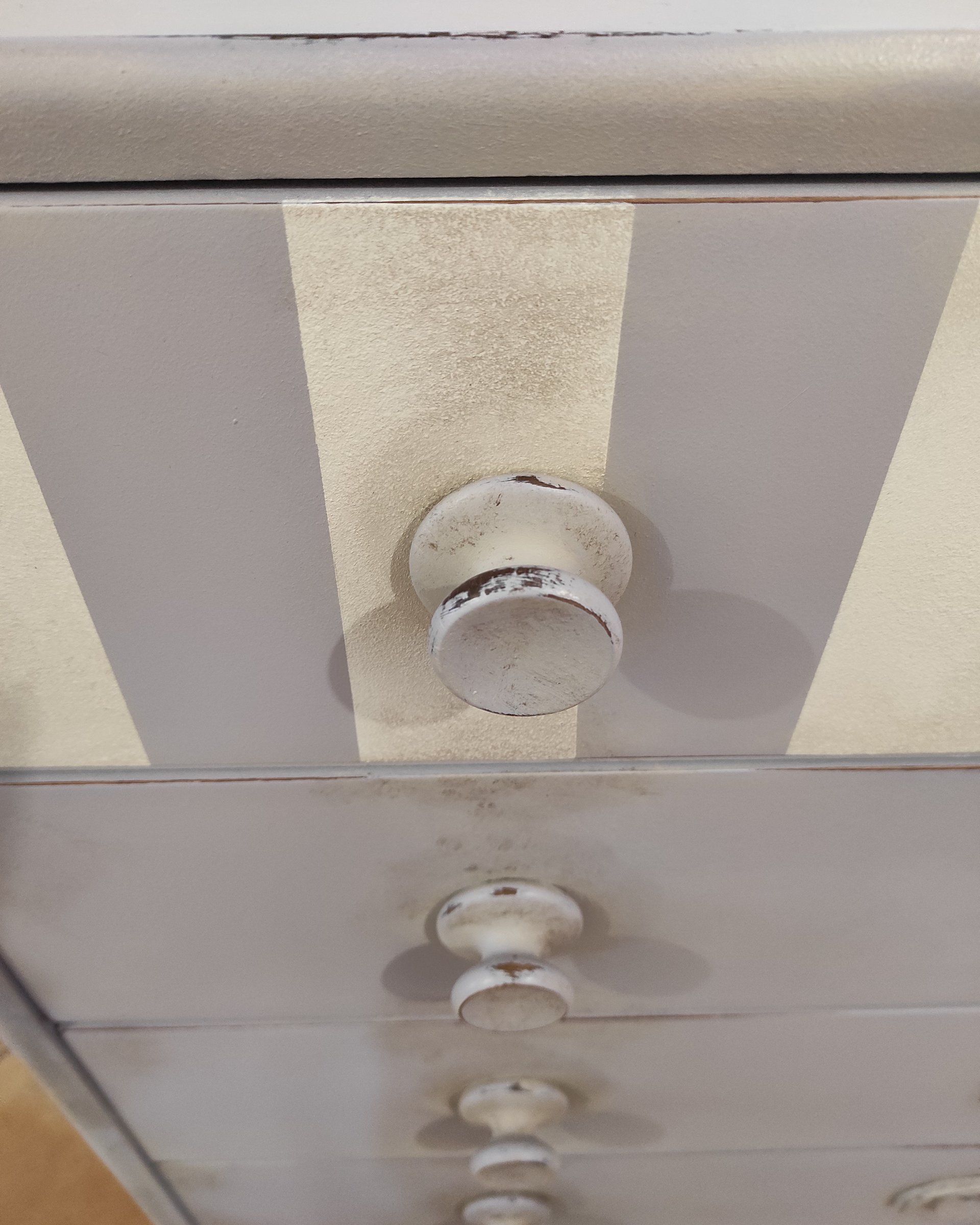 Pomello sul primo cassetto a righe, con i bordi scuriti effetto usura