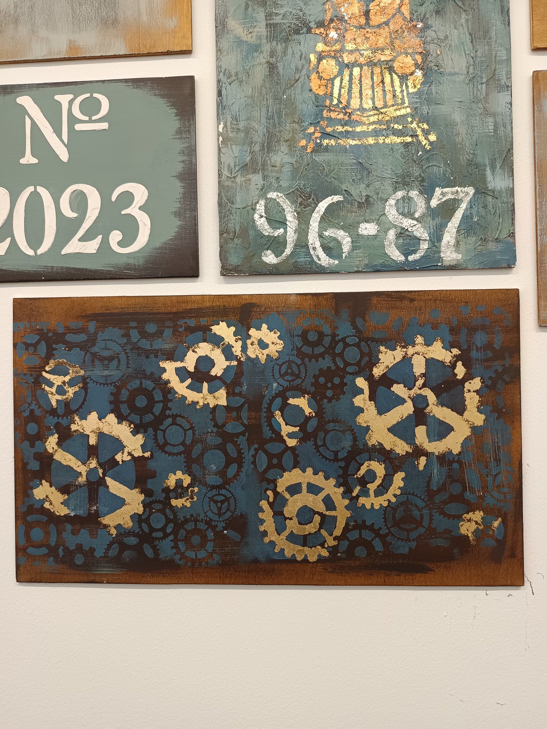 Tavola scura con ingranaggi in oro e tavola verde con numeri a stencil