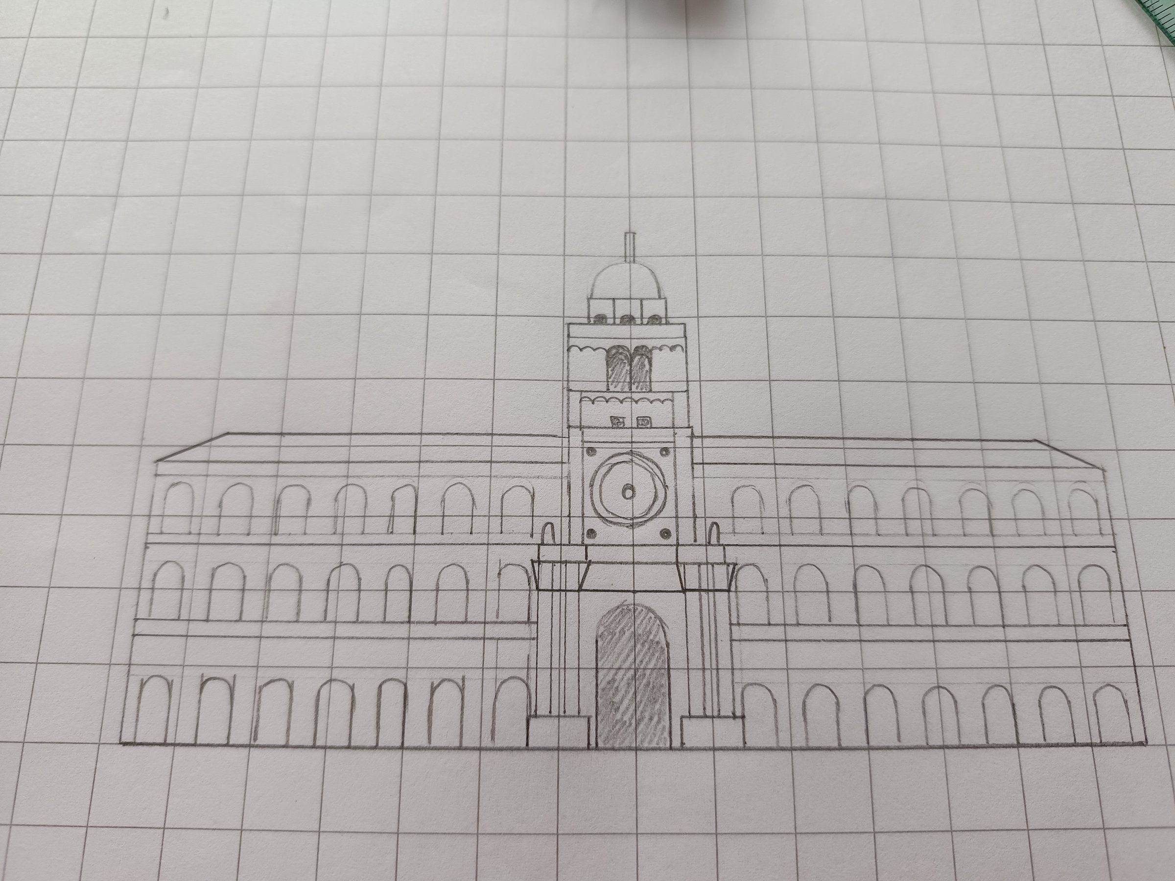 Fase di progetto: disegno a matita di un palazzo con torre su carta quadrettata