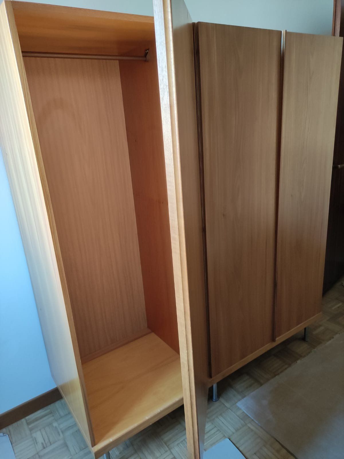 Armadio prima del restyling: moduli in finitura legno, con un'anta aperta
